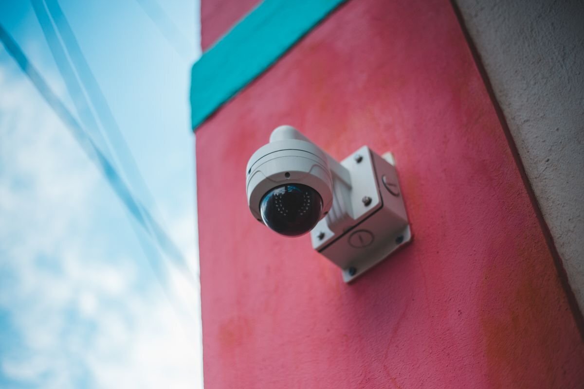 White dome security camera mounted under an eave