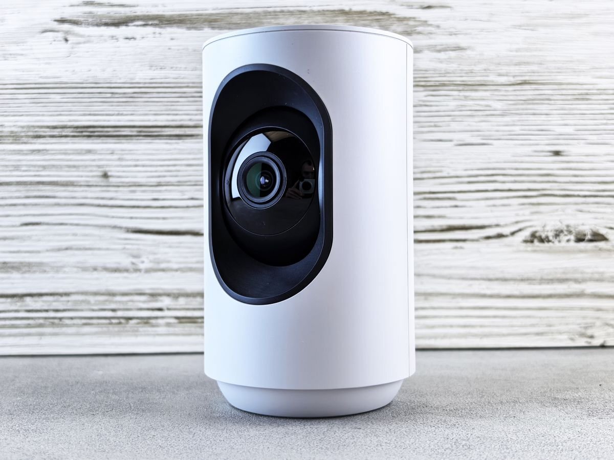 White indoor security camera on a wooden surface